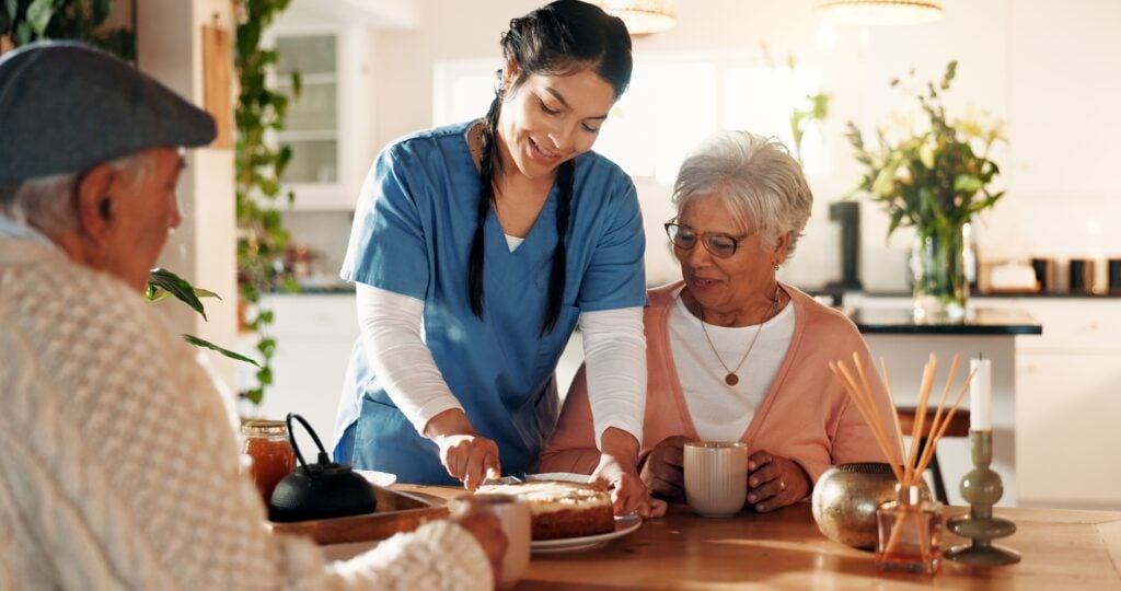 Happy,,Caregiver,And,Old,Couple,With,Cake,At,House,For